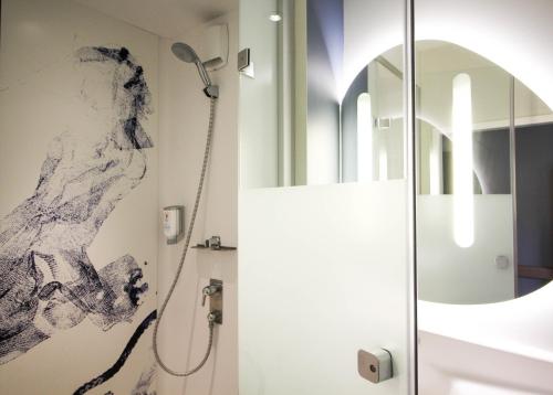 a bathroom with a shower and a mirror at ibis budget Muenchen Ost Messe in Aschheim