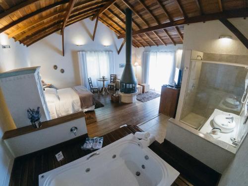 a room with a bath tub and a bedroom at Pousada Serra da Índia in Penedo