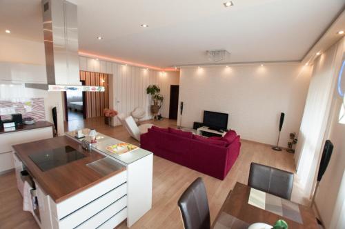 un soggiorno con un divano rosso e una cucina di Prestige apartment a Komárno
