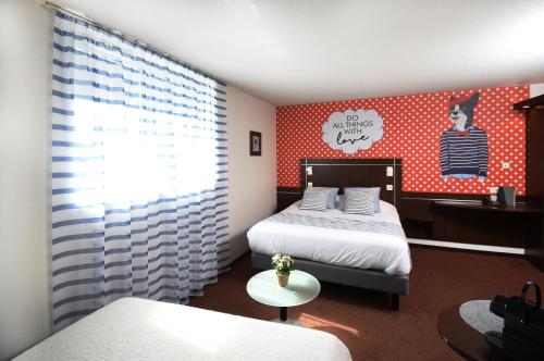 a bedroom with two beds and a red wall at Logis Boutique Hotel Novalis in Gradignan