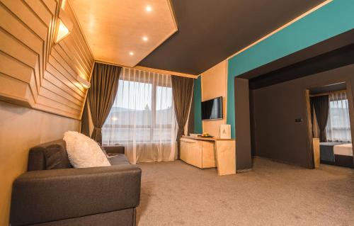 a living room with a couch and a window at Hotel Arte SPA & Park in Velingrad