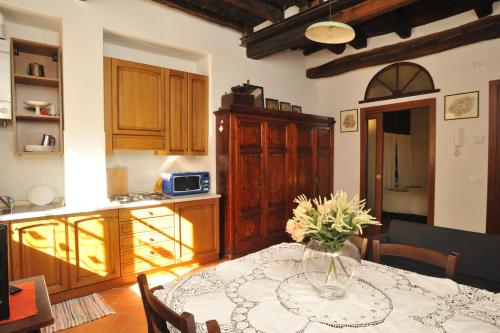 a kitchen with a table with a vase of flowers on it at Romantico 36 in Città della Pieve