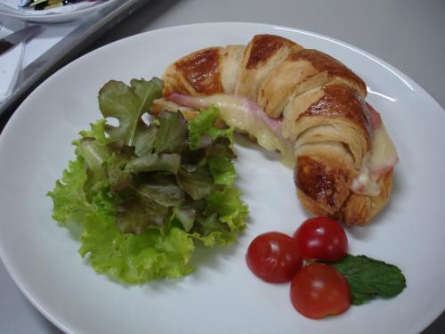 タウバテにあるEden Motel ( ADULT ONLY )のサンドイッチとサラダが添えられた食事の皿