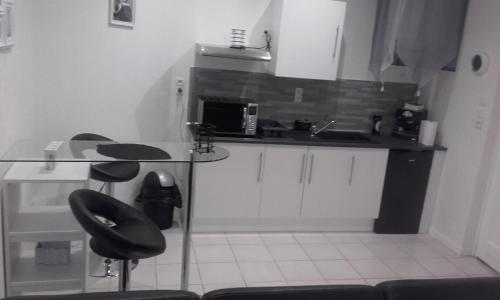 une cuisine avec une table et des chaises et un micro-ondes dans l'établissement Chez Zazouilles, à Pau