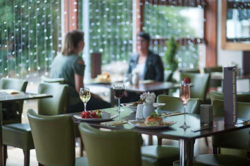 a man and woman sitting at tables in a restaurant at The Fullarton Park Hotel in Glasgow