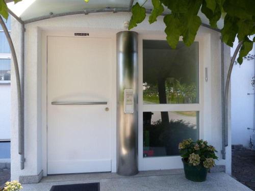 une porte d'une maison avec une usine à côté de celle-ci dans l'établissement Ferienwohnung-Sanwald, à Friedrichshafen