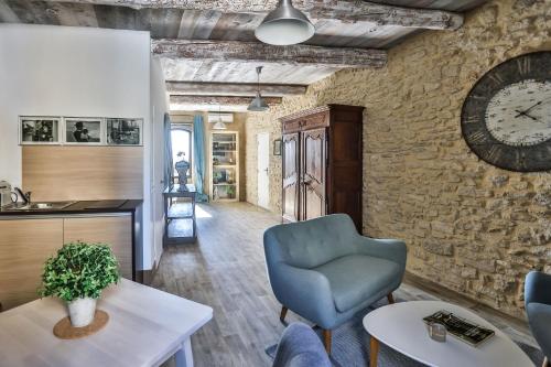 un salon avec une horloge au mur dans l'établissement Apartments - Experience of PROVENCE, à Gordes