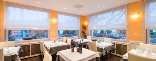 um restaurante com mesas e cadeiras e janelas grandes em Seiler's Hotel em Liestal