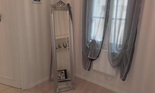 einen Spiegel in der Ecke des Badezimmers mit Vorhängen in der Unterkunft Chez Zazouilles in Pau