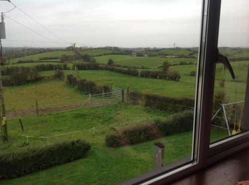 a window with a view of a green field at The Rock Equestrian Farm B&B in Bailieborough