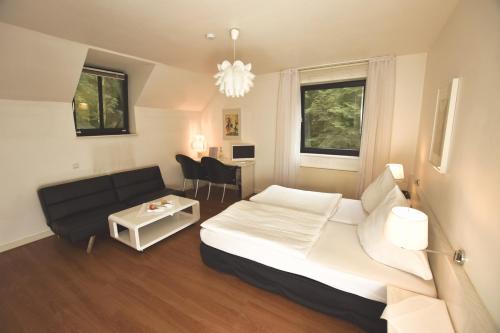een slaapkamer met een bed, een bank en een tafel bij Restaurant & Logis Steuerndieb in Hannover