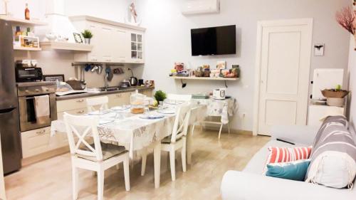 una cucina e una sala da pranzo con tavolo e sedie bianchi di B&B VelAmare a Salerno