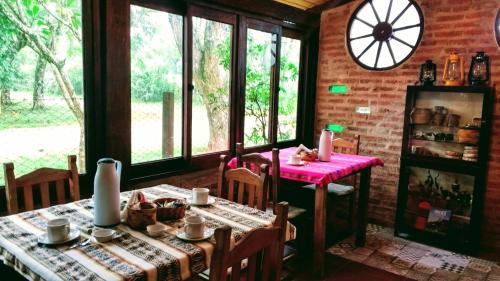 a dining room with a table and chairs and windows at Posada de las Huellas in Loreto