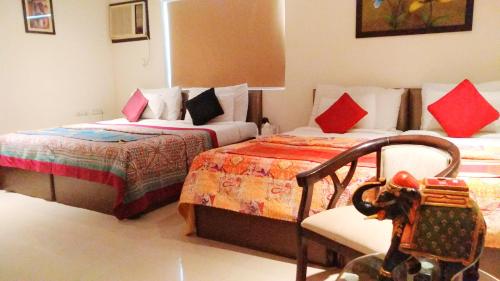 a bedroom with two beds and two lamps at Hotel Karan Vilas in Agra