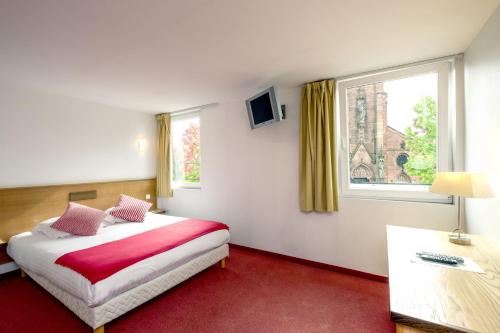 una camera d'albergo con letto e finestra di Hôtel Restaurant Notre Dame a Haguenau