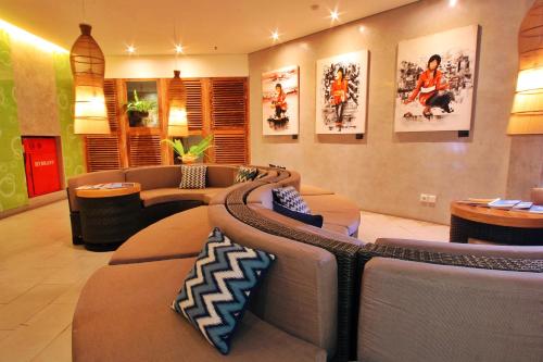 a living room filled with furniture and a couch at Grandmas Plus Hotel Airport in Kuta