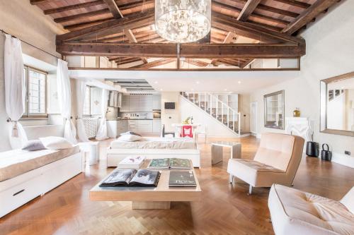 Elle comprend un salon doté d'un mobilier blanc et de plafonds en bois. dans l'établissement Duomo Luxury Loft, à Florence