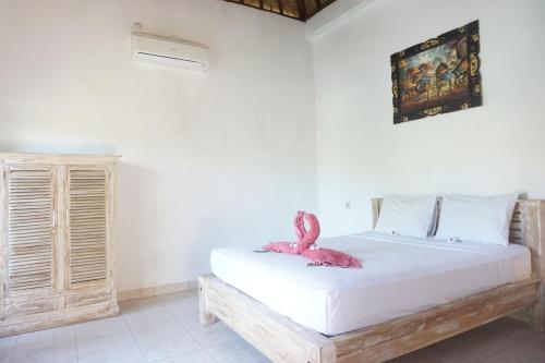 una camera da letto con un fenicottero rosa di Nyoman Guesthouse and Grill a Nusa Lembongan
