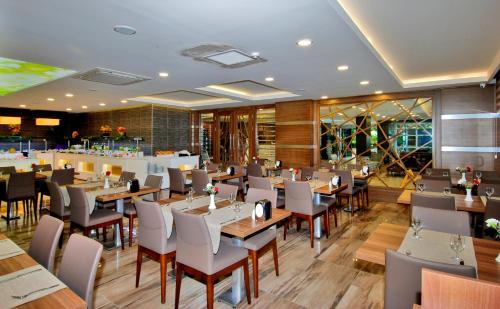 a restaurant with tables and chairs and a bar at Kleopatra Ramira Hotel - All Inclusive in Alanya