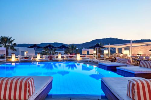 ein großer Pool mit Liegestühlen in einem Hotel in der Unterkunft Archipelagos Hotel - Small Luxury Hotels of the World in Kalo Livadi