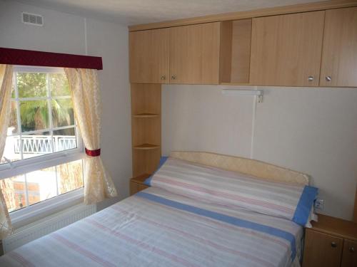 niewielka sypialnia z łóżkiem i oknem w obiekcie Camping Moraira w mieście Moraira