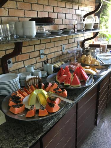 a buffet with several plates of food on a table at Pousada da Ladeira in Pipa