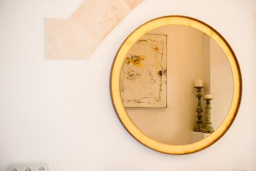 a round mirror on a wall with a lamp at S'Hotelet d'es Born - Suites & SPA in Ciutadella