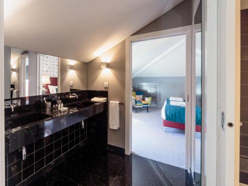a bathroom with a sink and a bedroom with a bed at Dear Lisbon - Gallery House in Lisbon