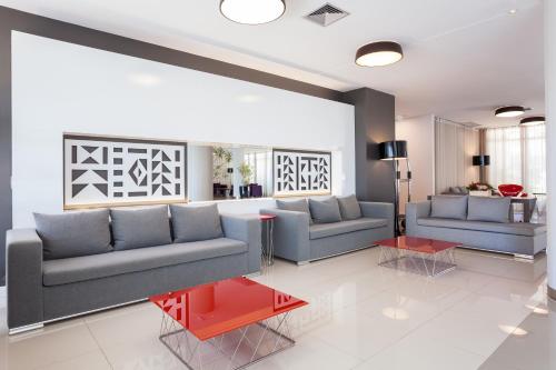 a living room with two couches and a table at eSuites Lagoa Santa in Lagoa Santa