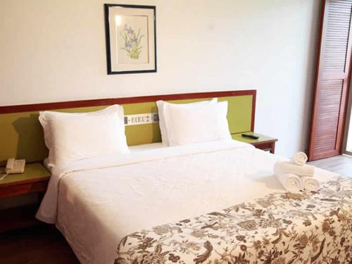 a hotel room with a large bed with white sheets at Aguas Mornas Palace Hotel in Santo Amaro da Imperatriz