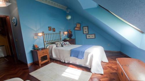 a blue bedroom with a bed and a blue wall at Apartamento Area Mayor in Malpica