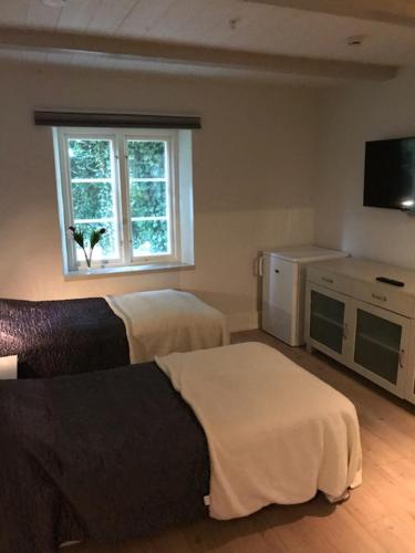 a hotel room with two beds and a window at Mullbärsgårdens Bed and Breakfast in Visby