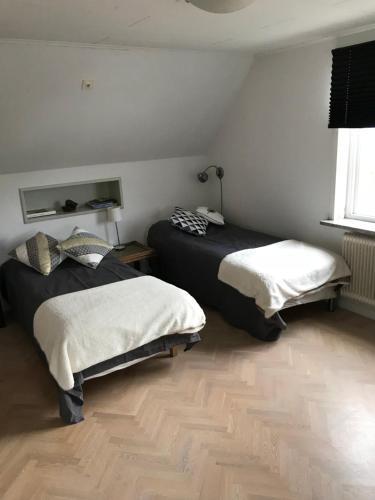 a bedroom with two beds and a window at Mullbärsgårdens Bed and Breakfast in Visby
