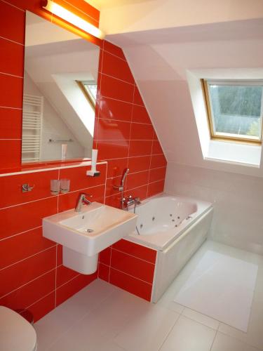 a red bathroom with a sink and a bath tub at Penzión VODÁR in Donovaly