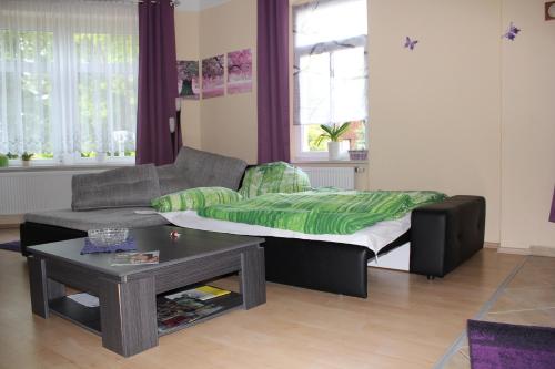a living room with a couch and a bed at Ferienwohnung am Schunckpark in Dresden