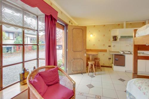 a living room with a chair and a kitchen at Apart Hotel Blumenau in Osorno
