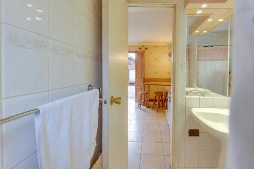 uma casa de banho com um chuveiro, um lavatório e um espelho. em Apart Hotel Blumenau em Osorno