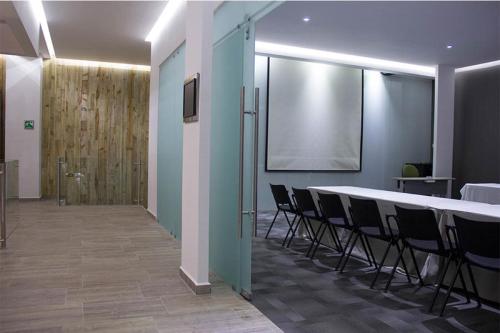 a meeting room with a white table and chairs at NEhotel Nueva Estancia in León