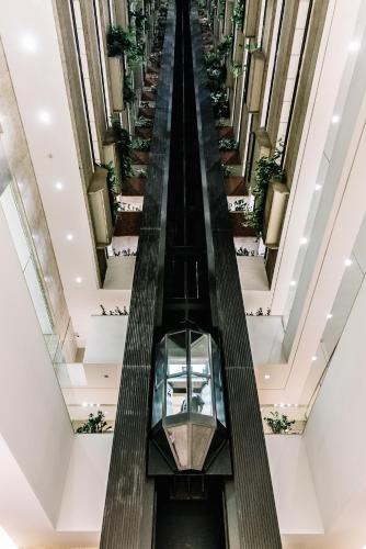 an escalator in a mall with potted plants at Transamerica Belo Horizonte Lourdes in Belo Horizonte