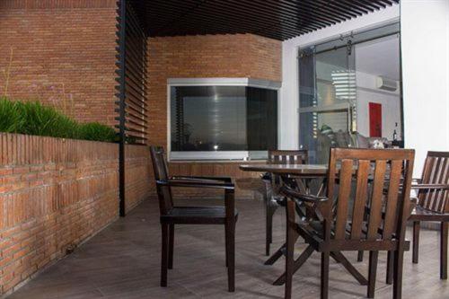 a patio with a table and chairs and a brick wall at NEhotel Nueva Estancia in León