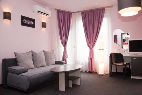 ein Wohnzimmer mit einem Sofa und einem Tisch in der Unterkunft Gran Via in Burgas City