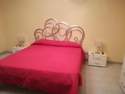a bedroom with a pink bed with two night stands at Principessa e ranocchio in Custonaci