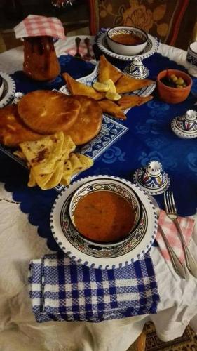 a table with a plate of food and a bowl of soup at Dar El Kasba Riad Guest House in Bizerte