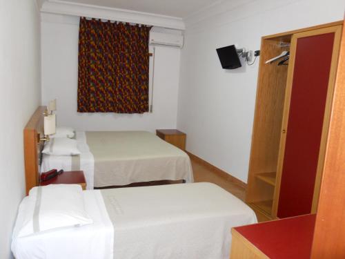 a hotel room with two beds and a window at Grand Hotel Pavone in Cassino