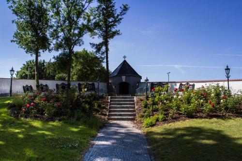 a path leading to a small chapel with a building at Hotel Panství Dlouhá Lhota in Dlouhá Lhota