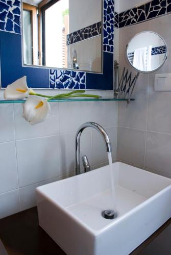 a white sink in a bathroom with blue and white tiles at Hotel Rural Casa Fontequeiroso in Muxia