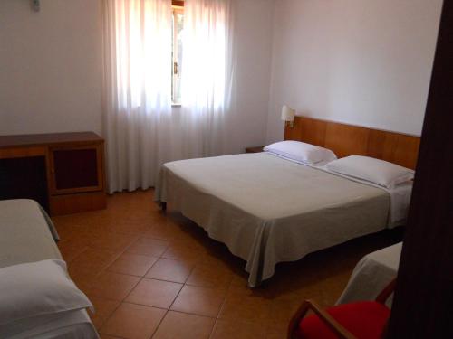 a hotel room with two beds and a window at Grand Hotel Pavone in Cassino