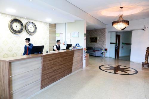two people sitting at a counter in a room with laptops at Larison Economy by Easy Hotéis in Porto Velho