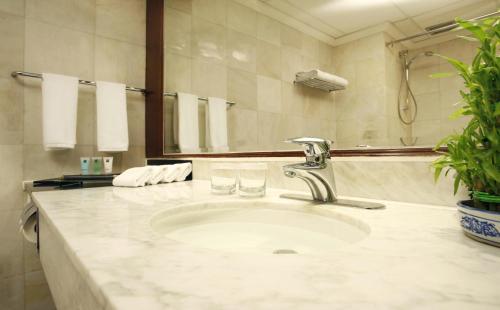 a bathroom with a sink with two glasses on it at Metropark Lido Hotel Beijing in Beijing