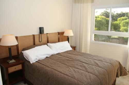 オステンデにあるAyres del Esteのベッドルーム1室(ランプ2つ、窓付)
